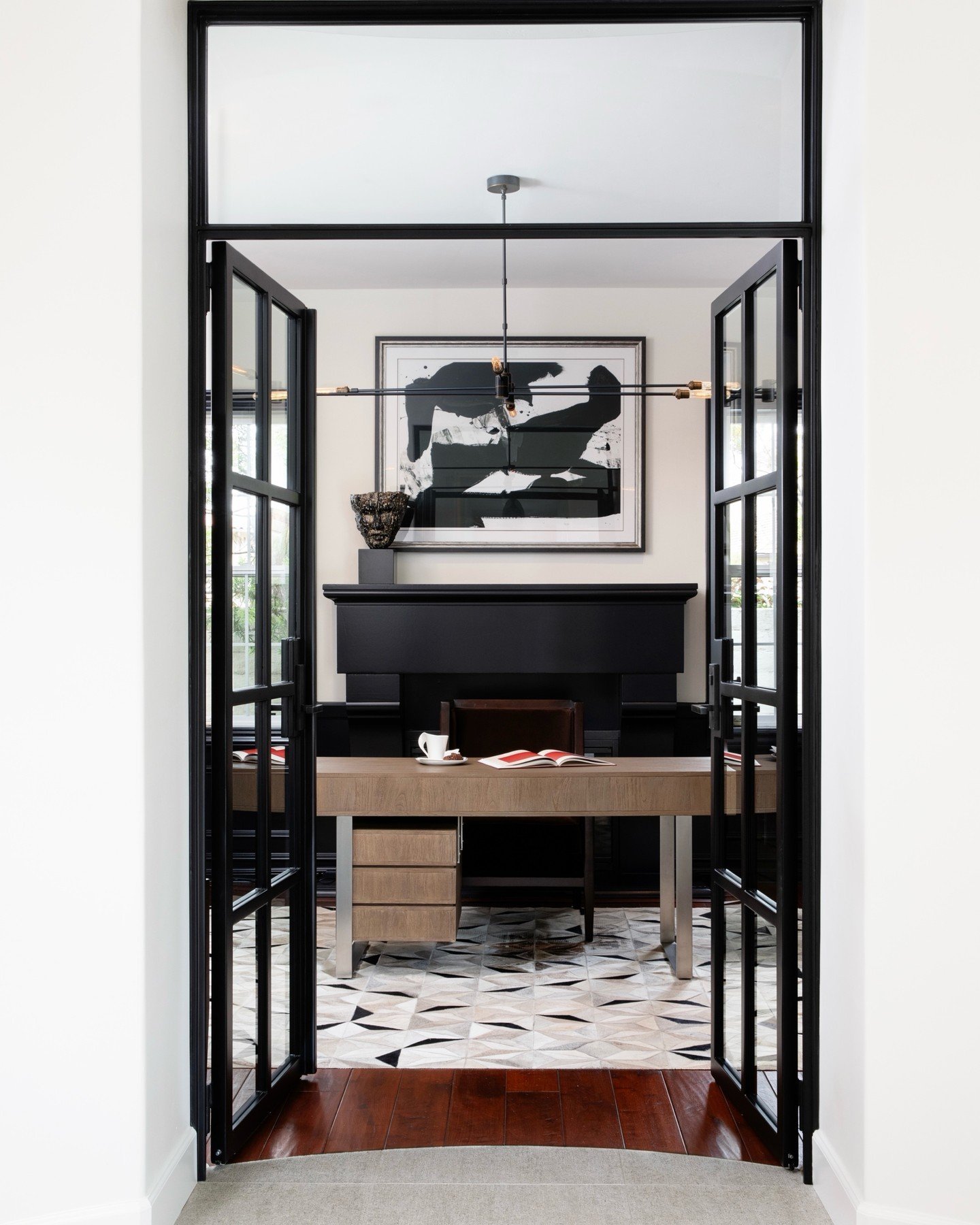 Glamorous and high style defined this chic couple's remodel project. Reflective materials, luxurious velvets, and stunning light fixtures set the tone. The indigo bar with metal mesh doors creates the perfect backdrop for serving delicious cocktails 